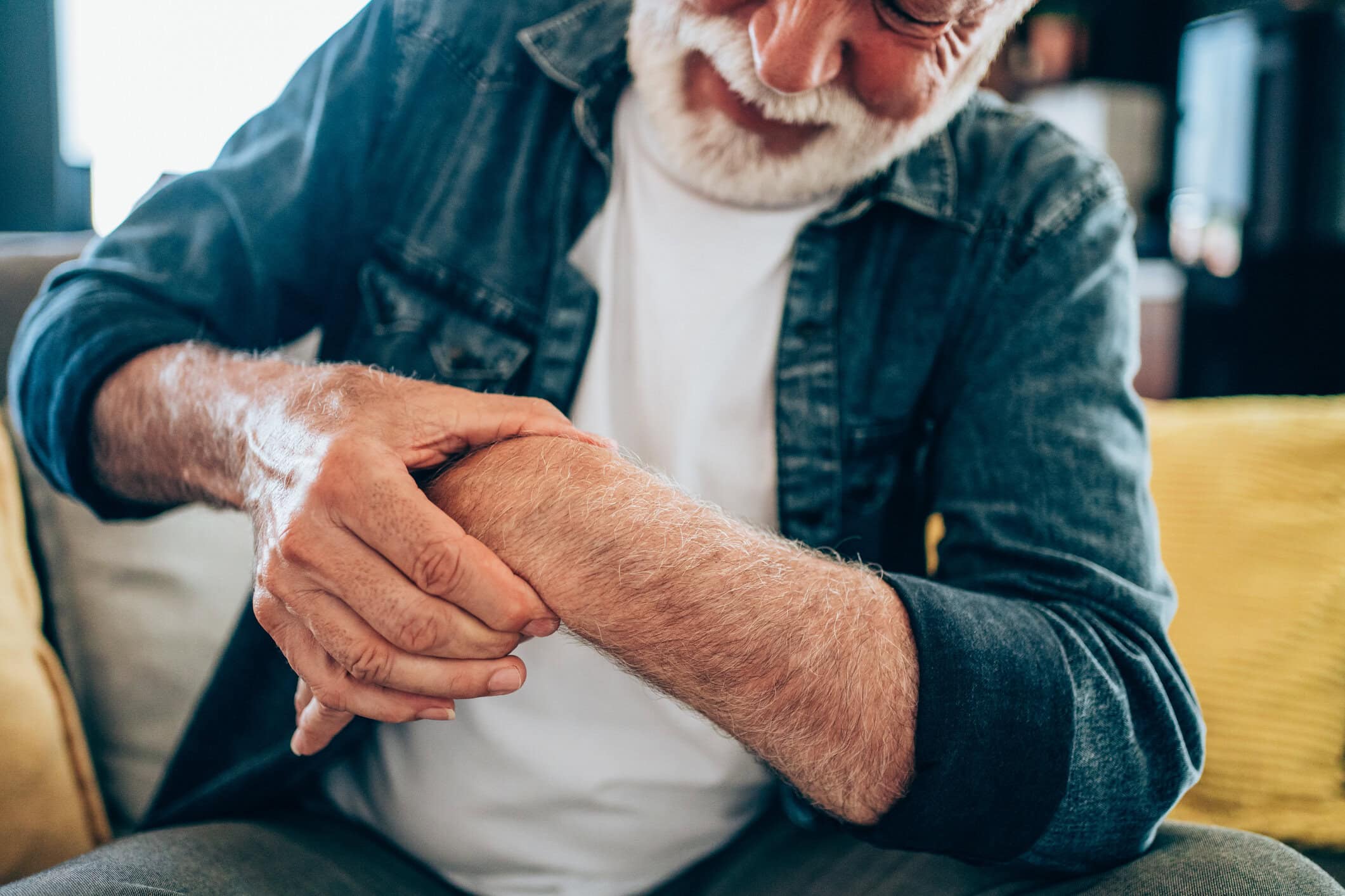 Older man holding wrist due to pain following an injury