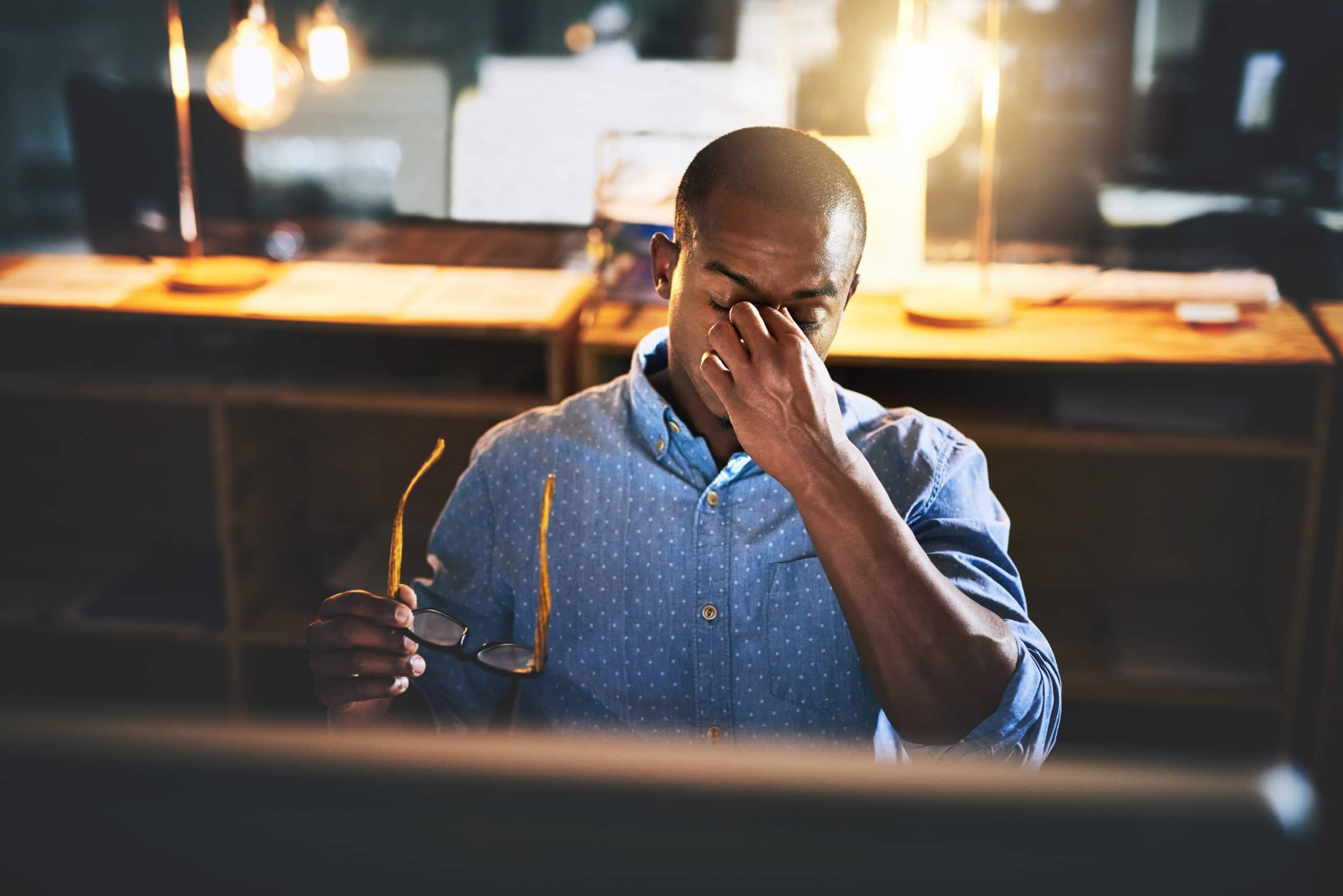 Man at computer with headache from screen use and desk posture